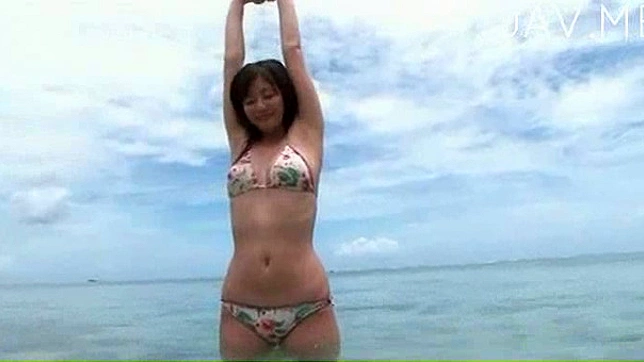 Chica japonesa guapa en bikini descansa en la playa